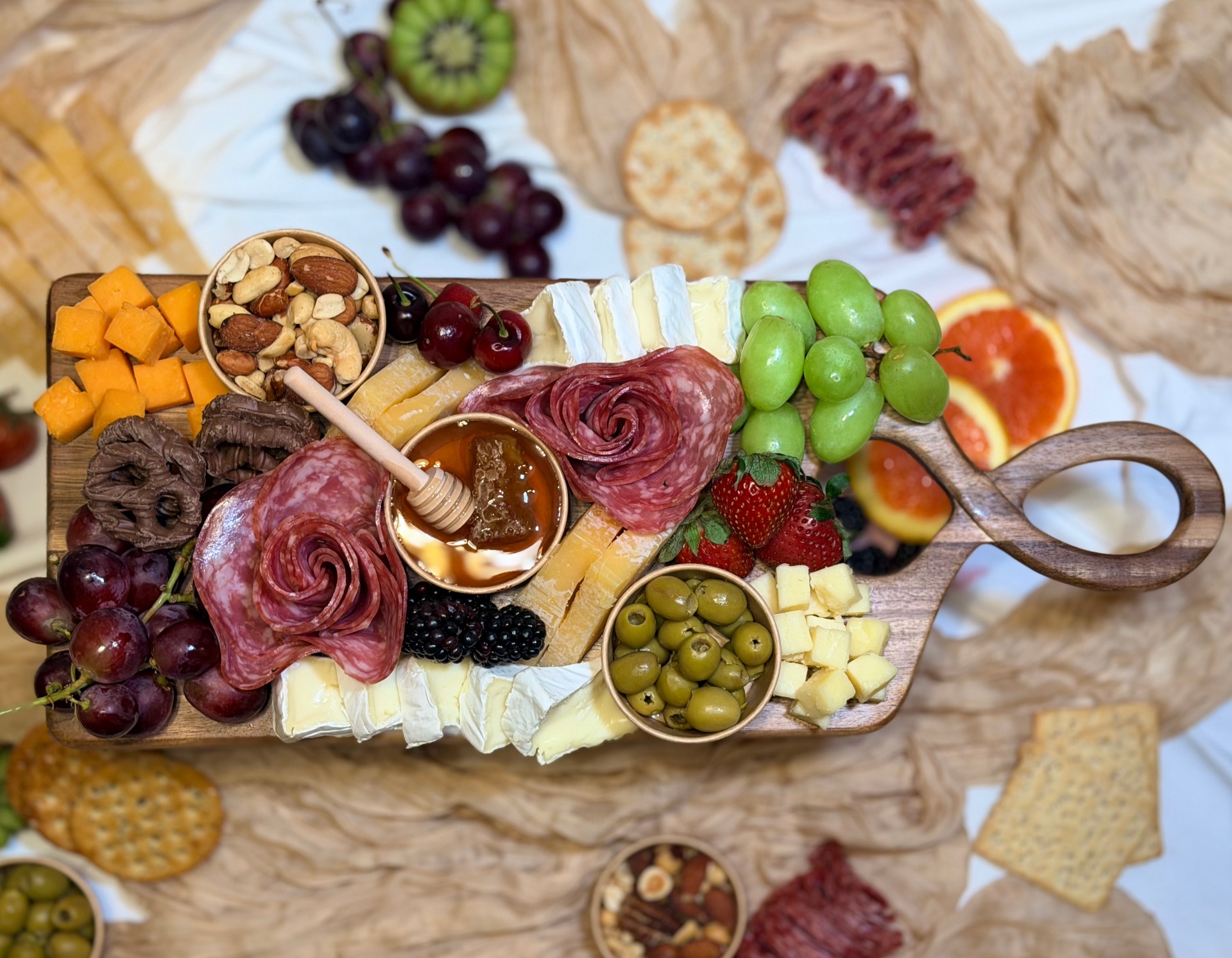Hands styling an artisan charcuterie box